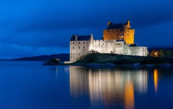 Schloss auf der Insel Eilean Donan, Schottland, während der blauen Stunde.